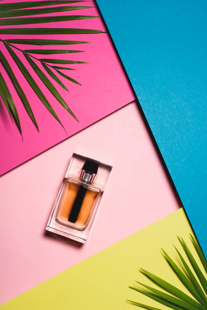 parfum déposé sur des feuilles de couleur 